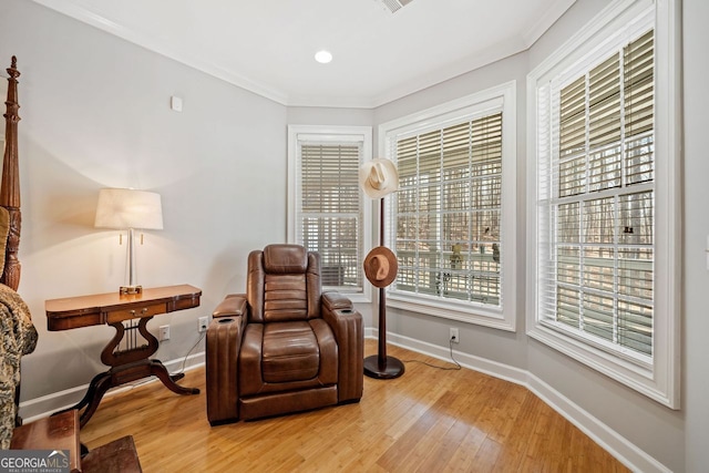 living area with baseboards, recessed lighting, light wood-style floors, and crown molding