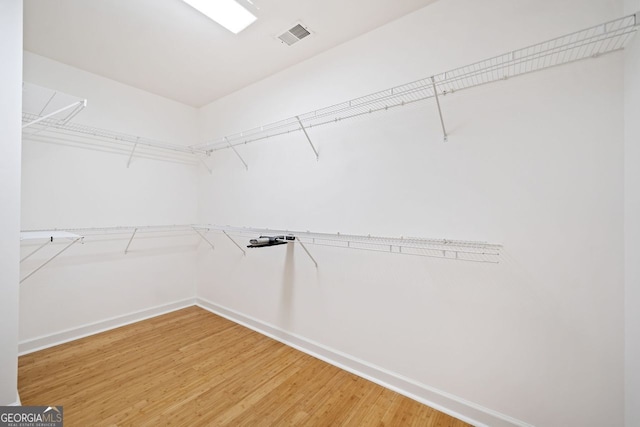 walk in closet with visible vents and wood finished floors