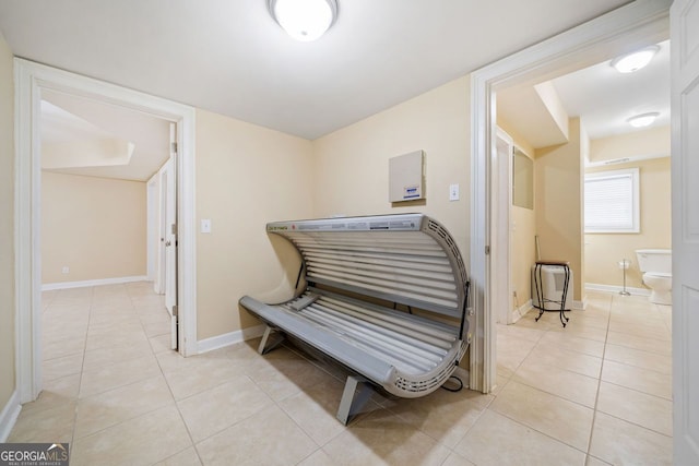 corridor with baseboards and light tile patterned floors