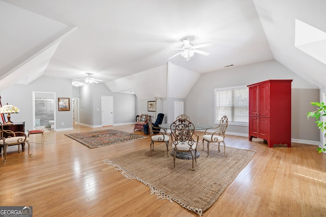 dining room featuring visible vents, baseboards, ceiling fan, vaulted ceiling, and light wood-style floors