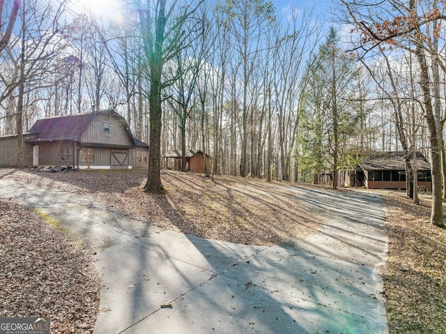 view of side of home with a barn, an outdoor structure, and a gambrel roof