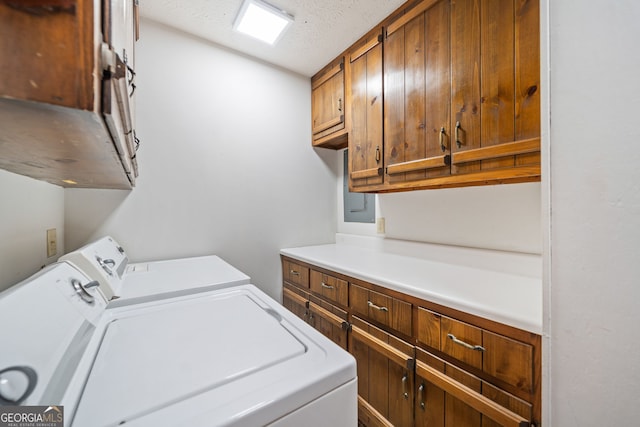 clothes washing area with a textured ceiling, cabinet space, and washer and clothes dryer