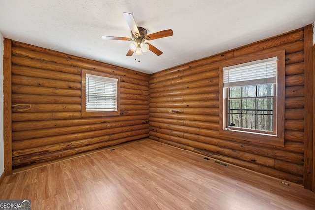 unfurnished room featuring visible vents, a ceiling fan, light wood-style floors, and a textured ceiling