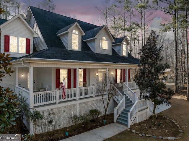 view of front of property featuring a porch, stairs, and a shingled roof