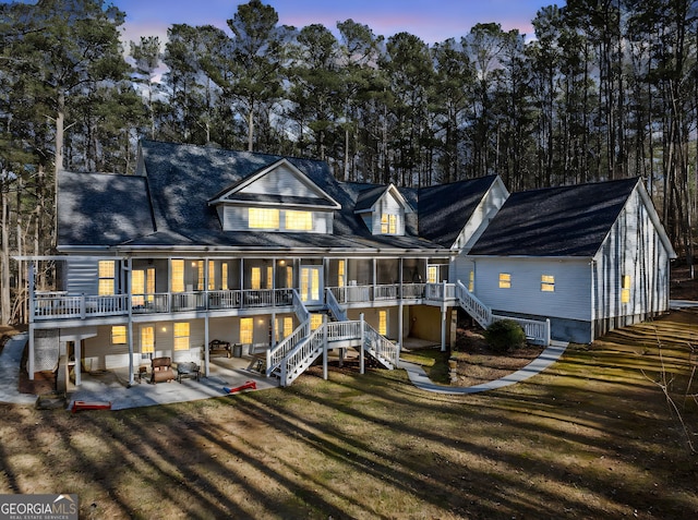 rear view of property with a lawn, stairway, and a patio area