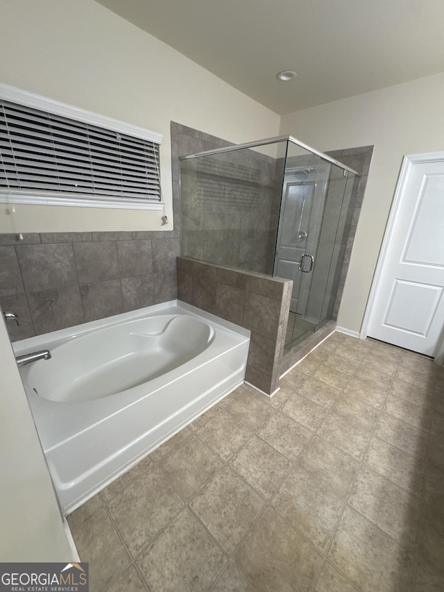 bathroom featuring shower with separate bathtub