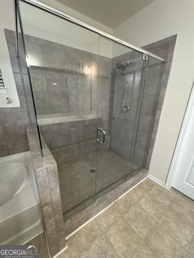 bathroom featuring tile patterned flooring and shower with separate bathtub