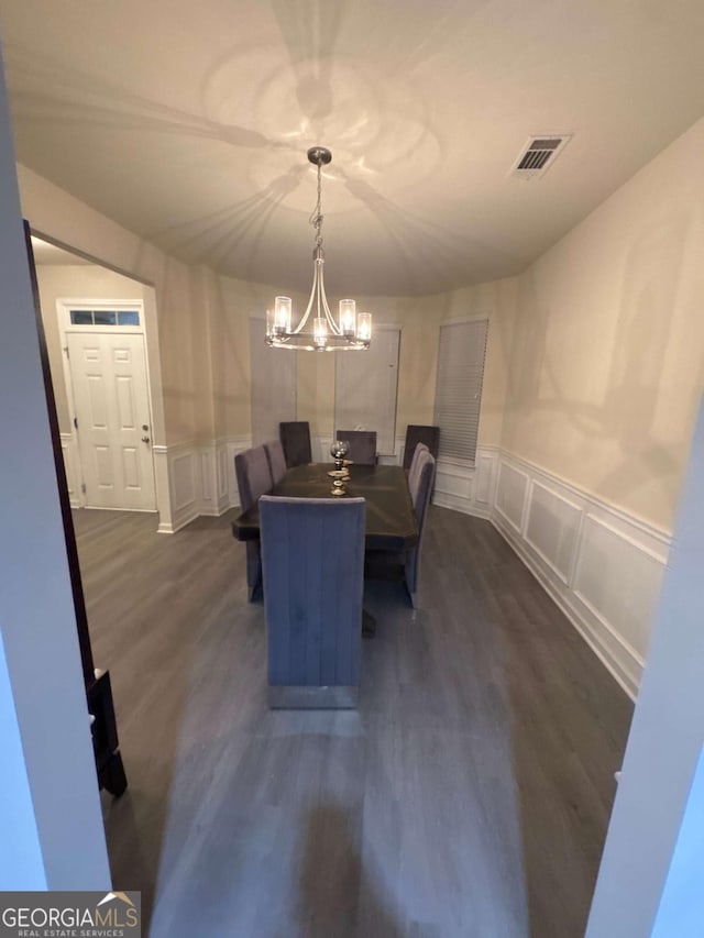 dining room featuring an inviting chandelier and dark wood-type flooring