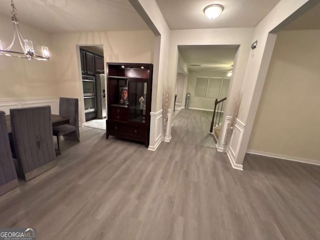 hall with hardwood / wood-style flooring and a notable chandelier