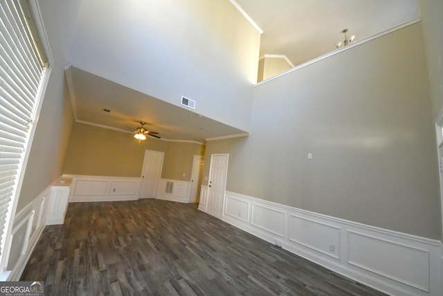 unfurnished living room with dark wood-type flooring, ornamental molding, and ceiling fan