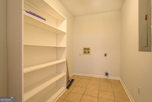 washroom featuring electric panel, hookup for a washing machine, light tile patterned floors, a textured ceiling, and hookup for an electric dryer