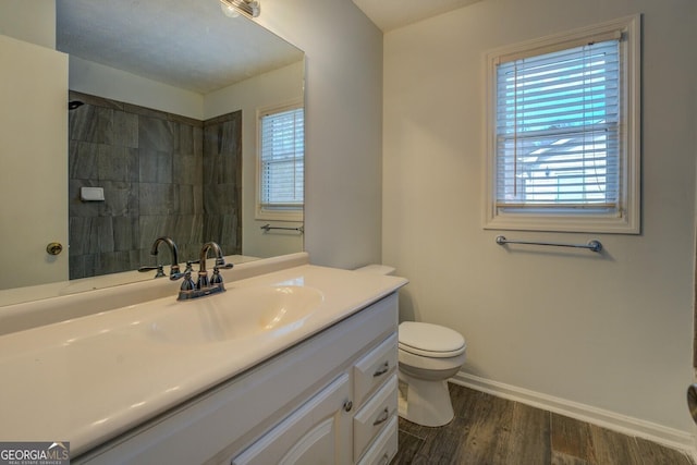 bathroom with hardwood / wood-style floors, vanity, and toilet