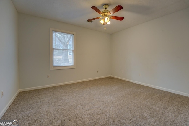 unfurnished room with ceiling fan and carpet