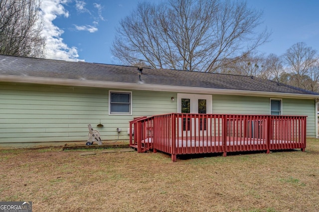 rear view of house with a deck and a yard