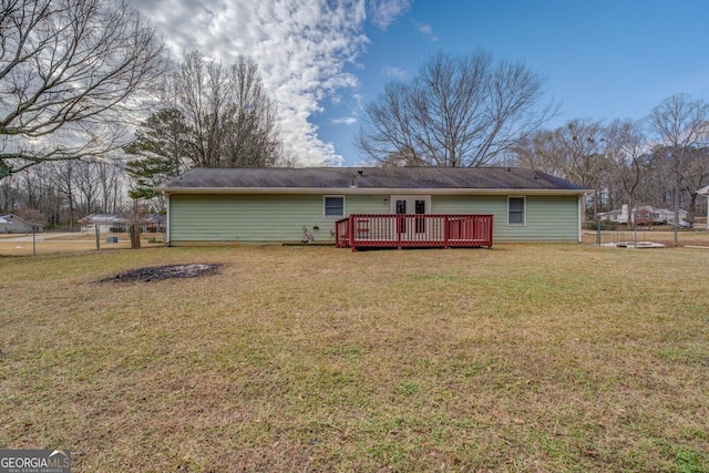 rear view of property with a deck and a lawn