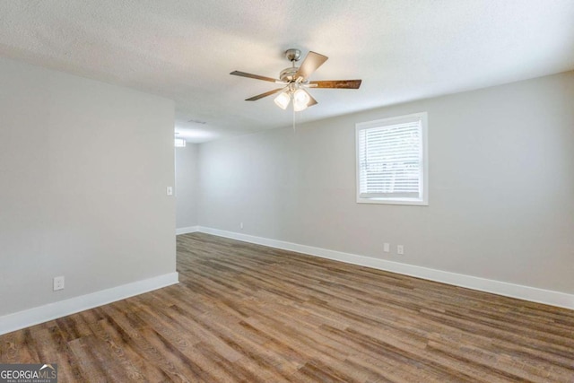 unfurnished room with a textured ceiling, dark hardwood / wood-style flooring, and ceiling fan