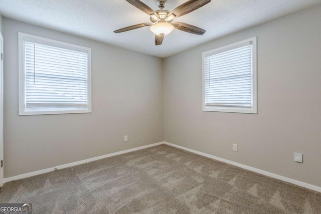 carpeted spare room featuring ceiling fan and a textured ceiling