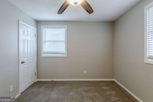 carpeted spare room featuring ceiling fan and a textured ceiling