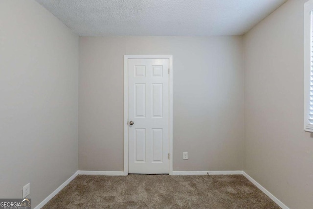 unfurnished room with carpet floors and a textured ceiling