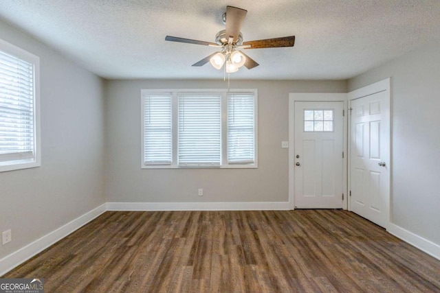 entrance foyer featuring a textured ceiling, ceiling fan, and dark wood-type flooring