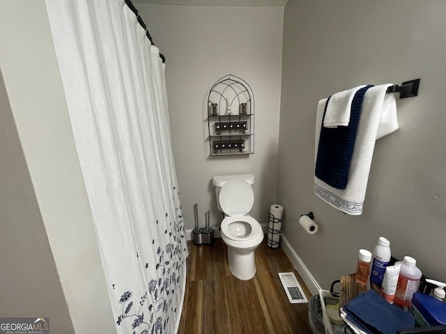 bathroom with hardwood / wood-style flooring and toilet