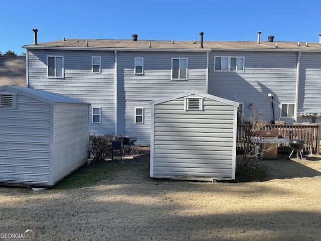 rear view of house featuring a yard and a storage unit