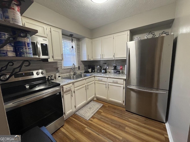 kitchen featuring white cabinetry, appliances with stainless steel finishes, sink, and backsplash