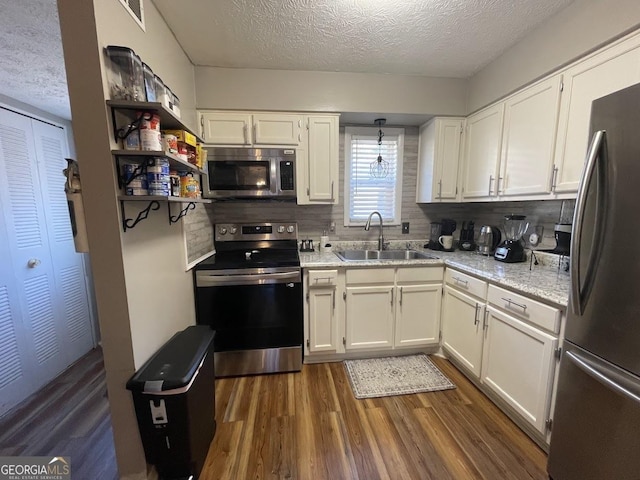 kitchen with white cabinetry, appliances with stainless steel finishes, sink, and a textured ceiling