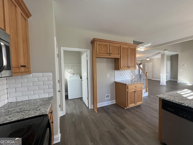 kitchen with light stone countertops, dark hardwood / wood-style floors, backsplash, washer / clothes dryer, and appliances with stainless steel finishes