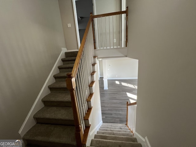 stairs featuring hardwood / wood-style floors