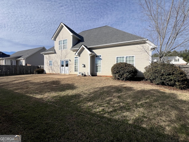 back of property featuring a patio area and a lawn