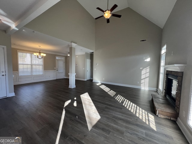 unfurnished living room featuring decorative columns, ceiling fan with notable chandelier, a high ceiling, and dark hardwood / wood-style floors