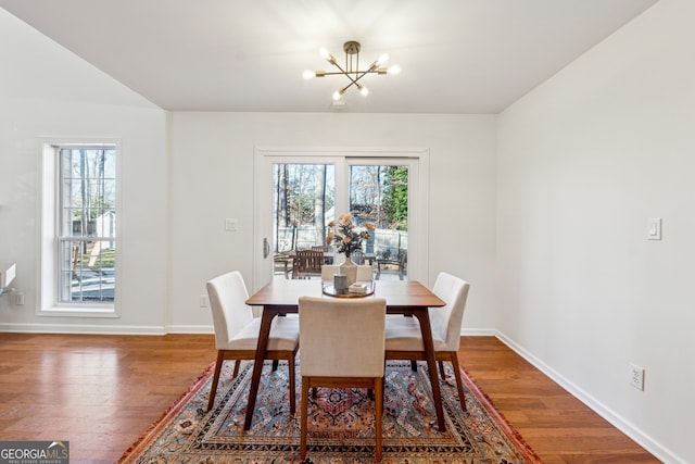 dining space with a notable chandelier and hardwood / wood-style floors