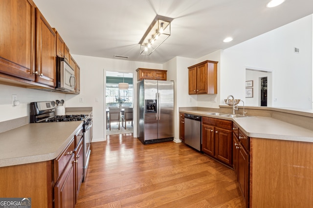 kitchen featuring appliances with stainless steel finishes, light hardwood / wood-style flooring, and sink