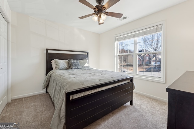 bedroom featuring ceiling fan, a closet, and light carpet