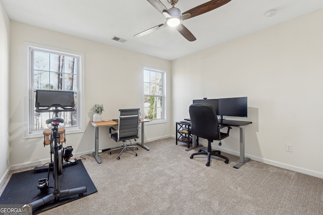 carpeted office space with ceiling fan and a healthy amount of sunlight