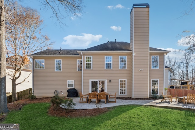 rear view of house with a patio and a lawn