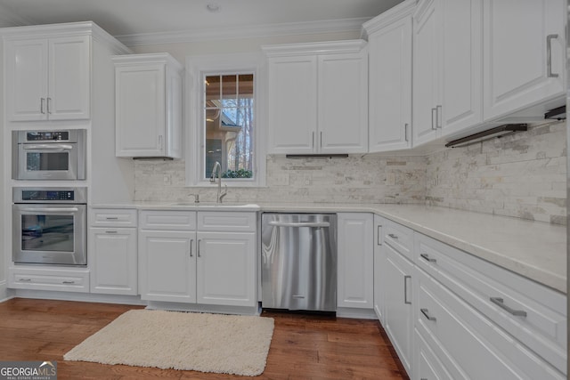 kitchen featuring tasteful backsplash, white cabinetry, sink, and appliances with stainless steel finishes