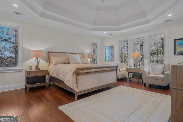 bedroom featuring dark hardwood / wood-style floors, a raised ceiling, multiple windows, and crown molding