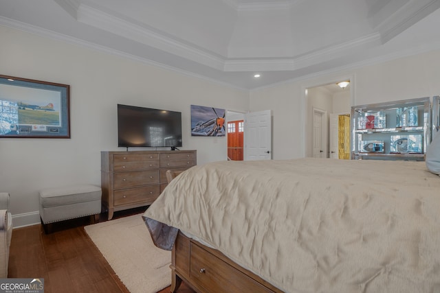 bedroom with dark hardwood / wood-style floors, a raised ceiling, and crown molding