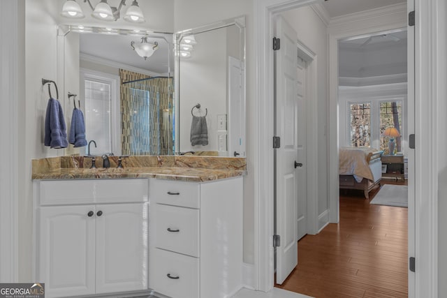 bathroom featuring a shower, crown molding, vanity, and hardwood / wood-style flooring