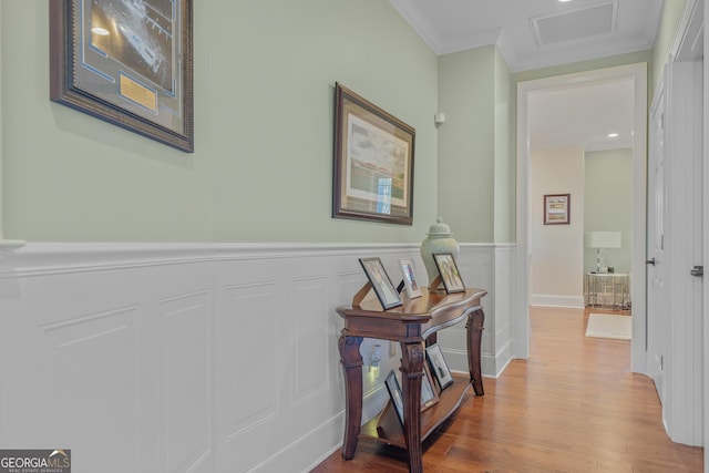 corridor with hardwood / wood-style floors and ornamental molding