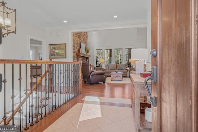 hall with crown molding, light tile patterned floors, and an inviting chandelier