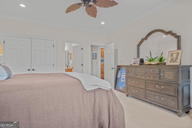 bedroom featuring ceiling fan, ornamental molding, connected bathroom, light colored carpet, and a closet