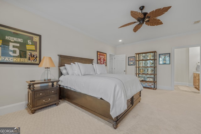 bedroom featuring light carpet, ensuite bath, ceiling fan, and ornamental molding