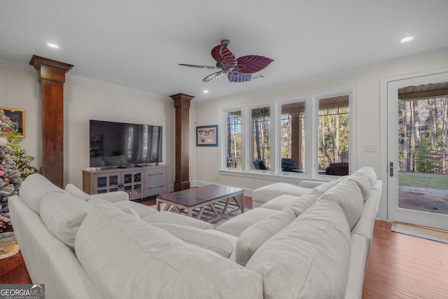 living room with hardwood / wood-style flooring, ceiling fan, crown molding, and decorative columns