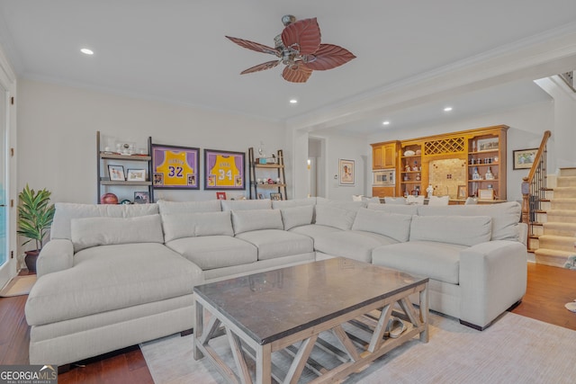 living room featuring hardwood / wood-style flooring, ceiling fan, and crown molding