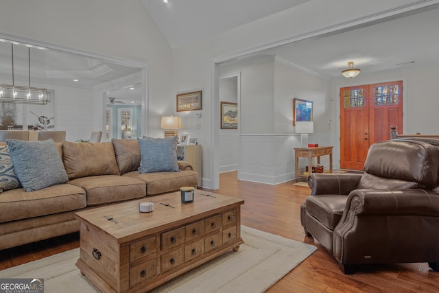 living room featuring ceiling fan, light hardwood / wood-style floors, and ornamental molding