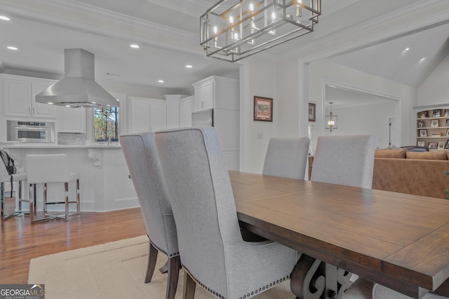 dining room with light wood-type flooring and ornamental molding