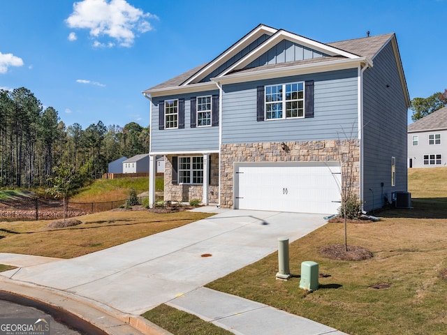 view of front of property featuring cooling unit, a garage, and a front lawn